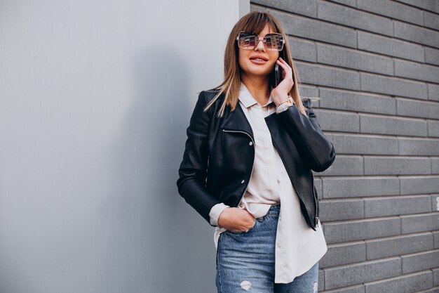 Young woman using phone by the shopping center