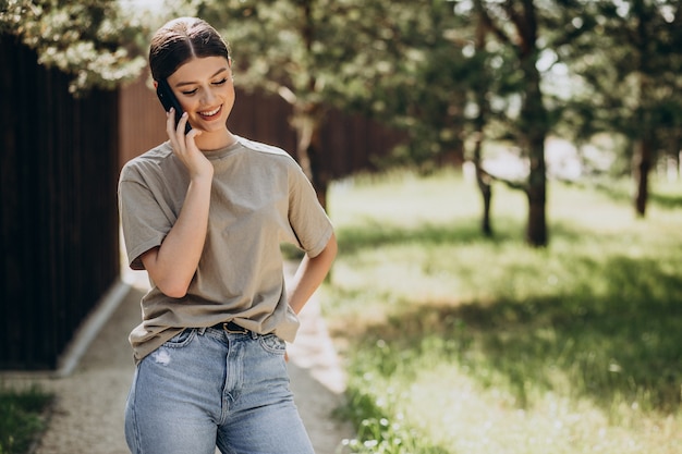 Foto gratuita giovane donna che usa il telefono fuori dalla strada