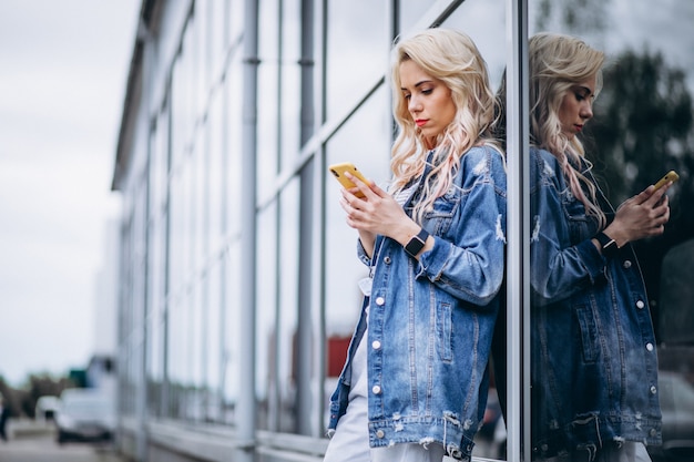 外の電話を使用して若い女性