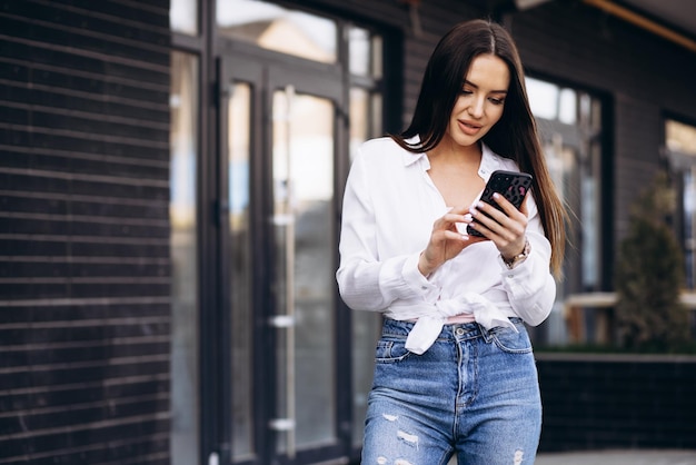 Young woman using phone at the street