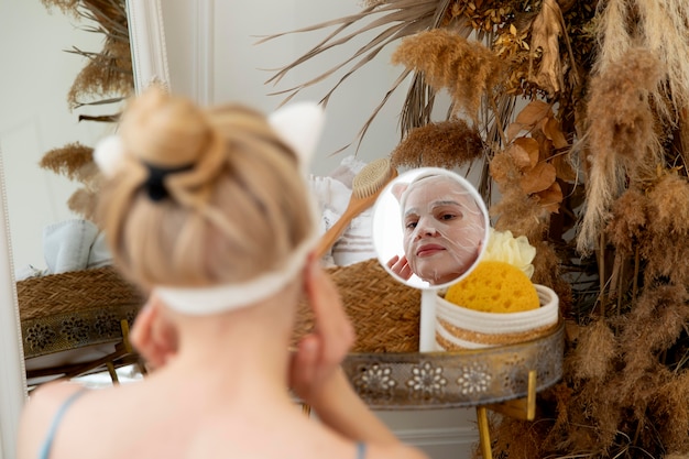 Free photo young woman using a selfcare face mask