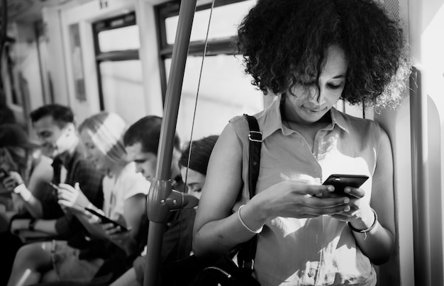 지하철에서 스마트폰을 사용하는 젊은 여성