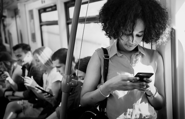 Foto gratuita giovane donna che utilizza uno smartphone in una metropolitana