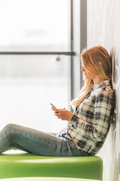 Free photo young woman using smartphone