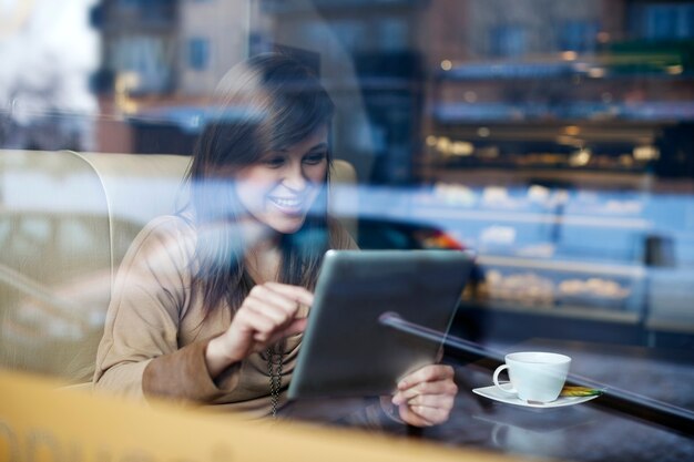 Young woman using tablet in coffee shop