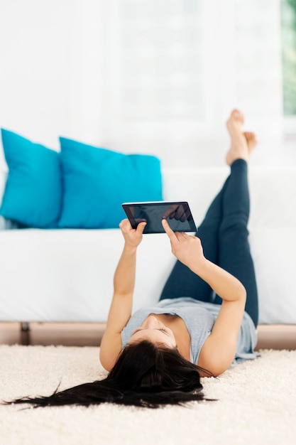 Young woman using tablet on the floor