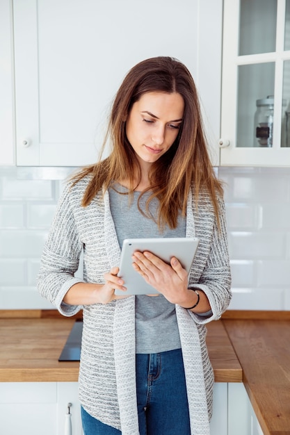 Young woman using tablet in kitchen