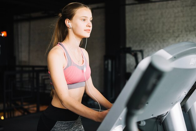 Young woman using treadmill