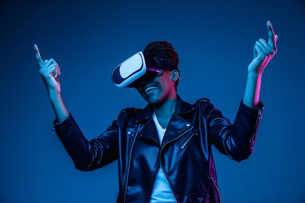 Молодая женщина, используя VR-очки с неоновыми огнями