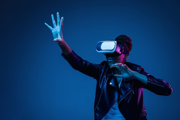 Young woman using VR-glasses with neon lights