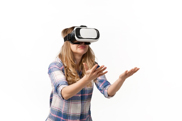 Young woman using VR-headset devices, gadgets isolated on white studio wall