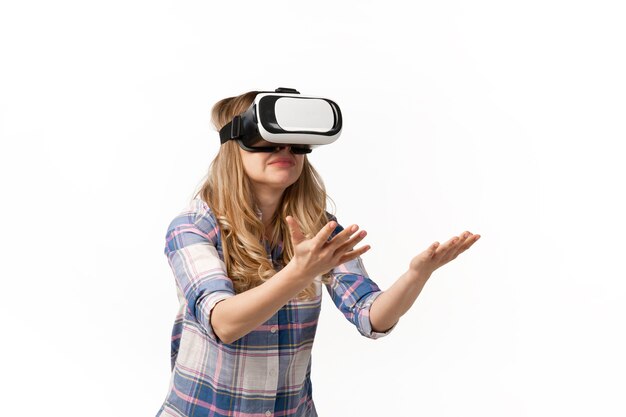 Молодая женщина, использующая устройства VR-гарнитуры, гаджеты, изолированные на белой стене студии