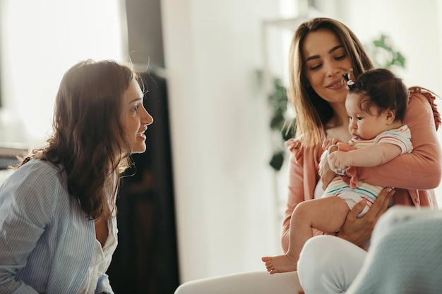 Giovane donna che visita un'amica e la sua bambina a casa