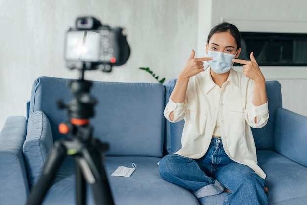 Young woman vlogging about medical masks