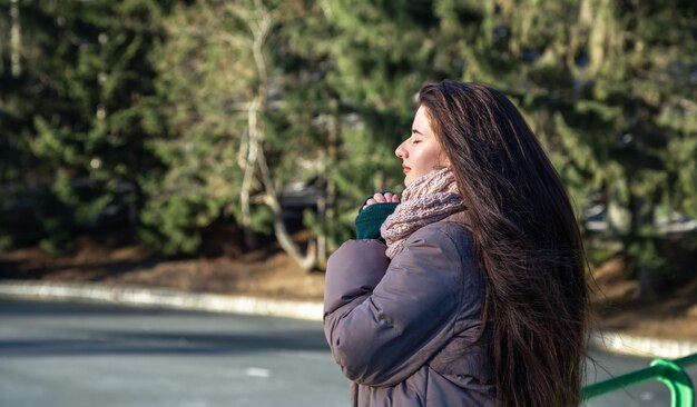 A young woman on a walk in the winter in the forest