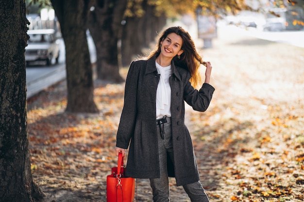 Foto gratuita giovane donna che cammina in un parco di autunno