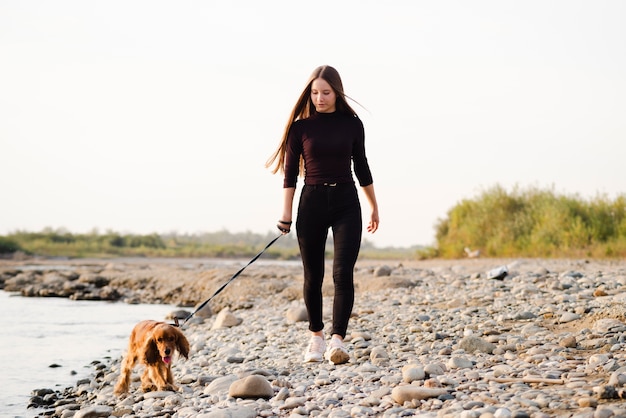젊은여자가 그녀의 강아지를 야외 산책