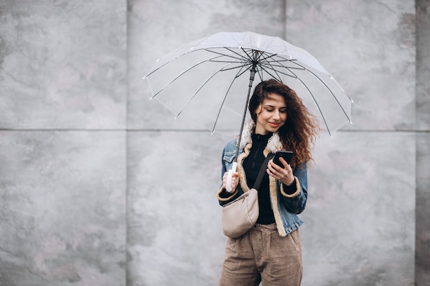 Young woman walking in the rain with umbrella