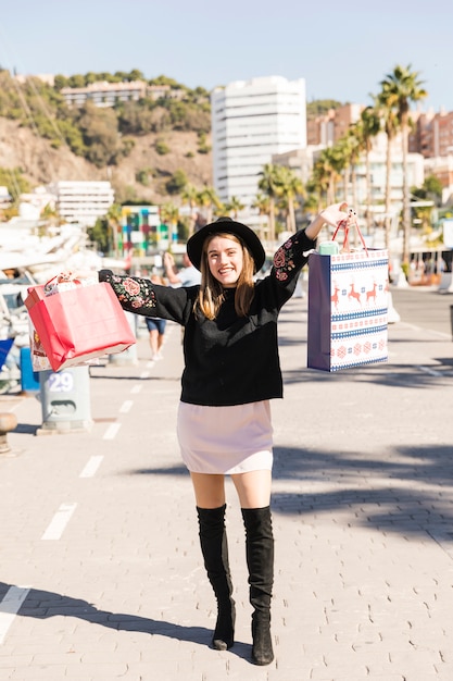 Young woman walking on street with shopping bags