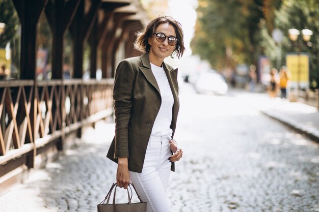 Young woman walking in town in sunglasses