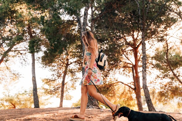 Young woman walking with her dog in park