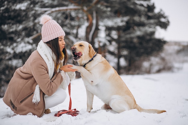 겨울 공원에서 그녀의 강아지와 함께 산책하는 젊은 여자