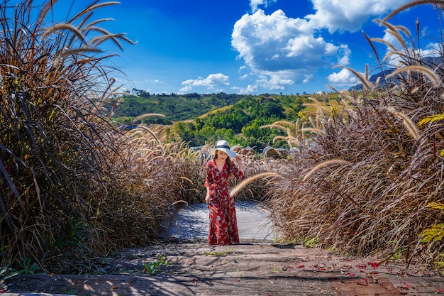 Young woman walking on wooden path.