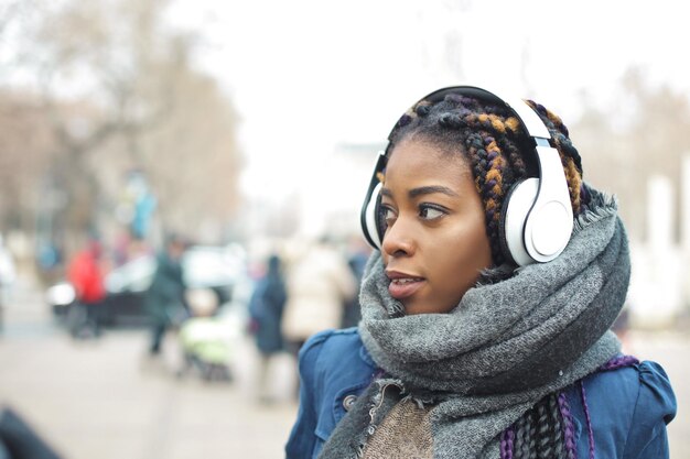 young woman walks down the street listening to music