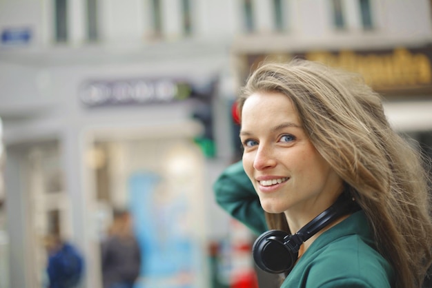 young woman walks down the street and listens to music