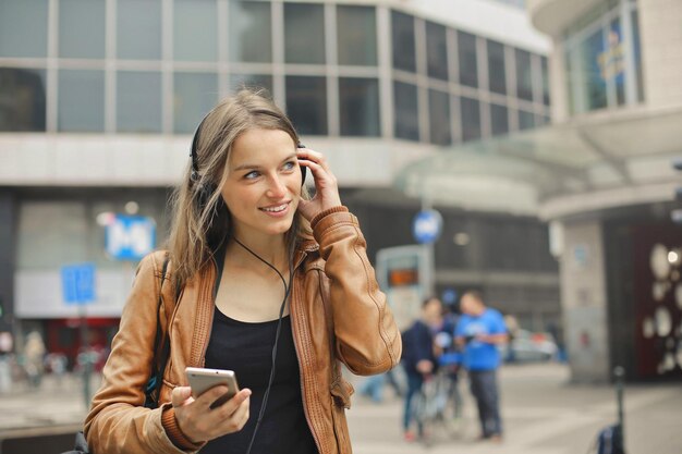 young woman walks down the street and listens to music