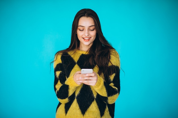 Young woman in a warm sweater using phone