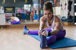 Foto gratuita riscaldamento della giovane donna in palestra