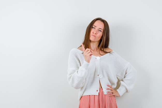 Free photo young woman warning with finger in cardigan and skirt looking spiteful isolated