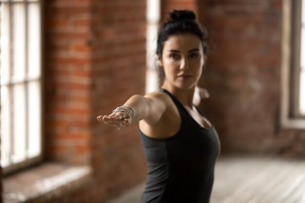 Young woman in Warrior II pose, close up