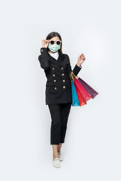 The young woman was dressed in dark, a mask and glasses and bags to go shopping