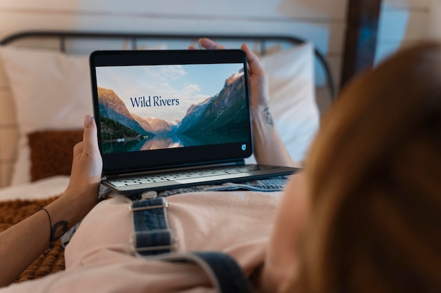 Free photo young woman watching a movie on streaming service at home