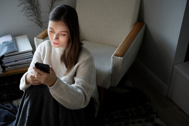 スマートフォンを使用してビデオを見ている若い女性