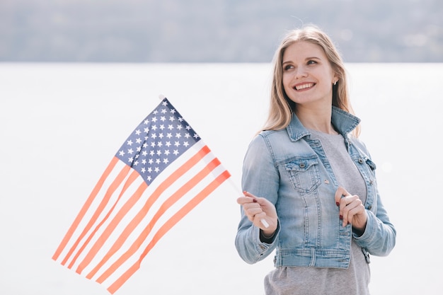 Foto gratuita giovane donna sventolando la bandiera usa