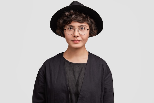 Free photo young woman wearing all black clothes and round eyeglasses