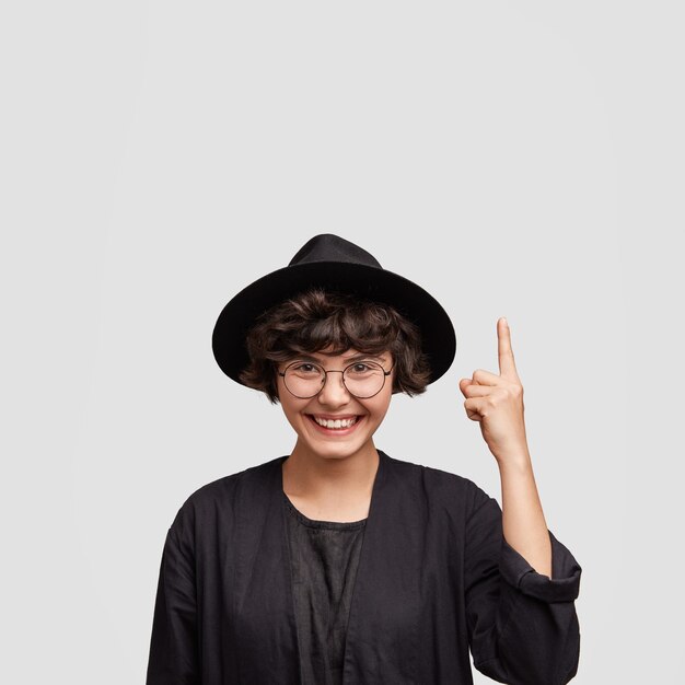 Young woman wearing all black clothes and round eyeglasses