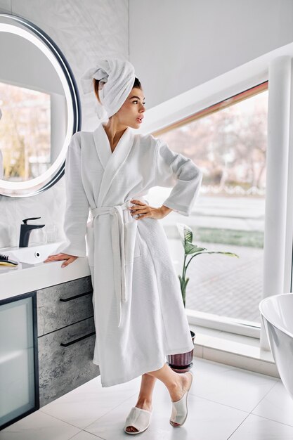 Young woman wearing a bathrobe and a towel on her hair