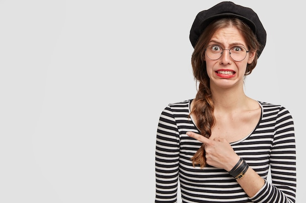 Foto gratuita giovane donna che indossa berretto e camicia a righe