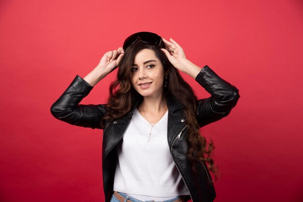 Young woman wearing black glasses on a red background. High quality photo