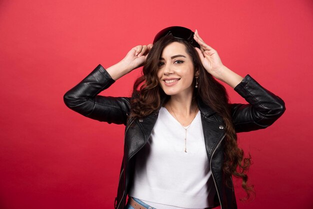 Young woman wearing black glasses on a red background. High quality photo