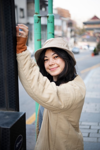 Free photo young woman wearing a bucket hat in the city