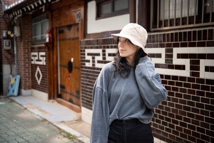 無料Photo 街でバケツ帽子をかぶった若い女性