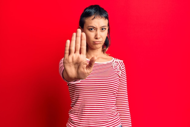 Foto gratuita giovane donna che indossa abiti casual che smette di cantare con il palmo dell'espressione di avvertimento della mano con gesto negativo e serio sul viso