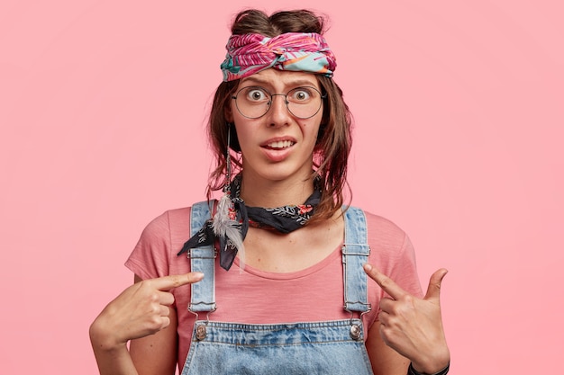 Free photo young woman wearing colorful headband and denim overalls