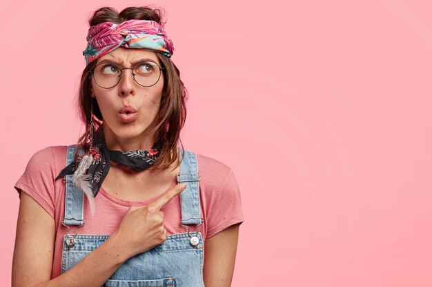 Young woman wearing colorful headband and denim overalls