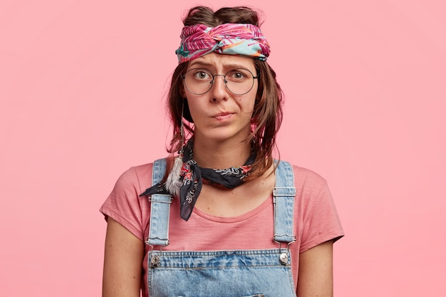 Free photo young woman wearing colorful headband and denim overalls